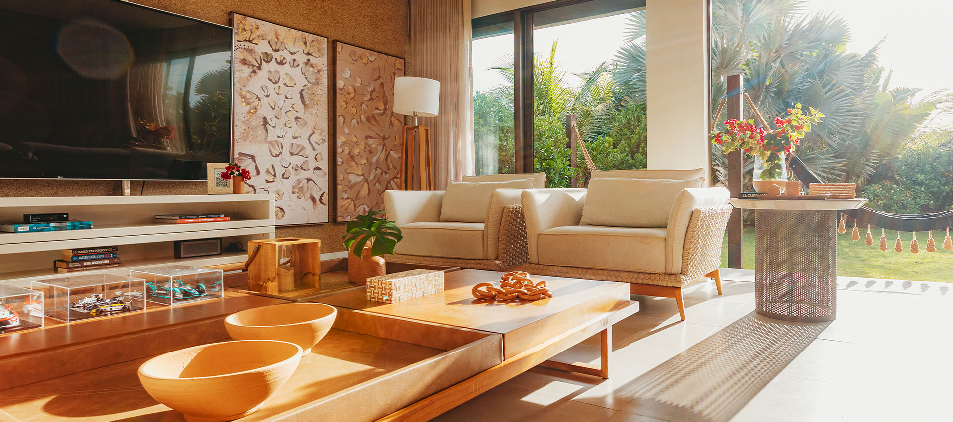 Sala de estar da Casa Lençóis com sofás, TV e decoração em tons naturais