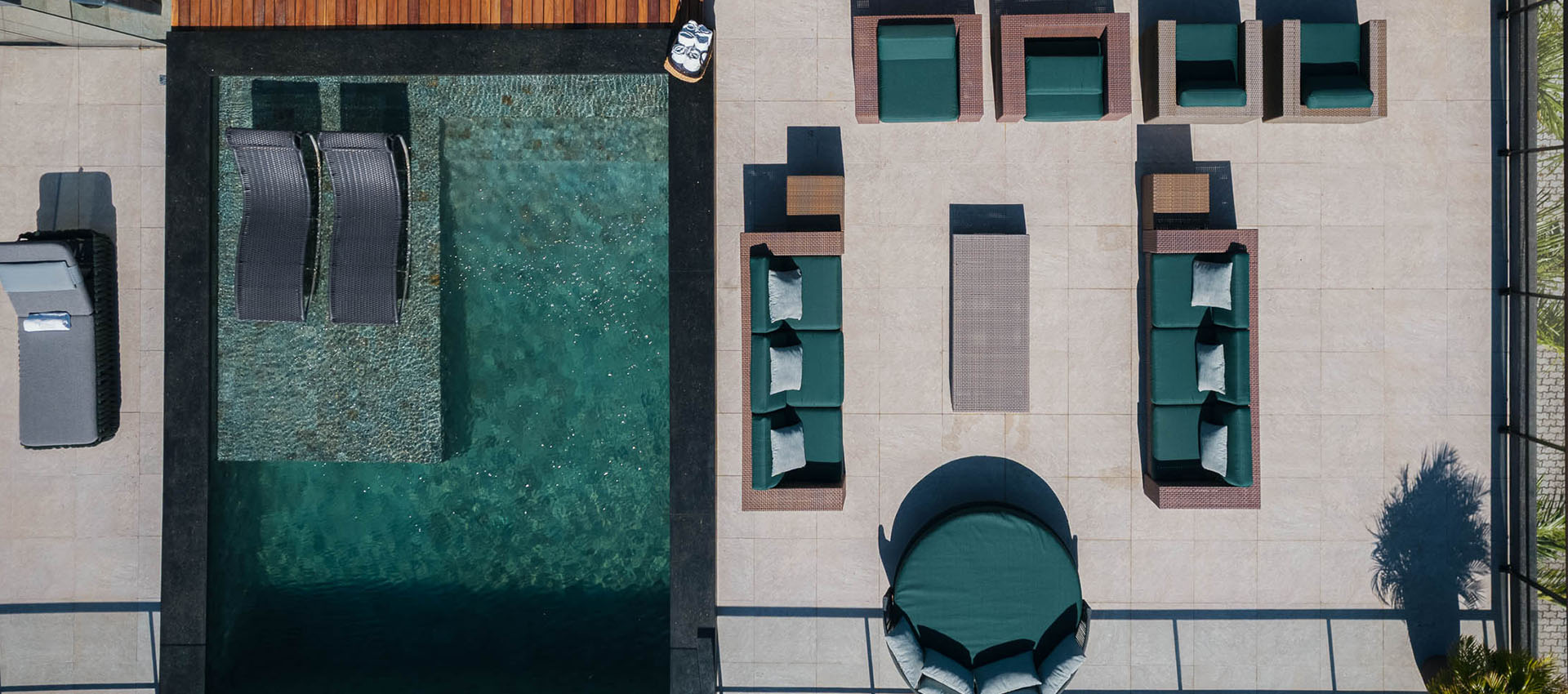 Vista aérea da piscina e área de estar com sofás no rooftop da Casa Lençóis